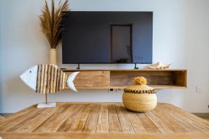 a living room with a television and a vase on a table at Tropica Bliss in Grand-Baie