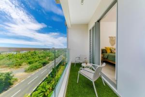 a bedroom with a balcony with a view of the ocean at Tropica Bliss in Grand-Baie