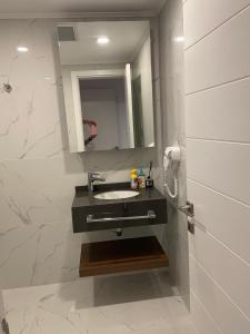 a bathroom with a sink and a mirror at Grand Sappfıre e4 in Larnaka +4 photos