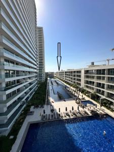 a large building with a swimming pool next to a building at Grand Sappfıre e4 in Larnaka