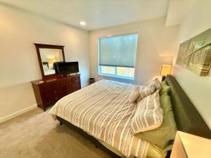 Garden Towers CondominiumModern Condo with Luxury Amenities的一间带床、电视和窗户的卧室