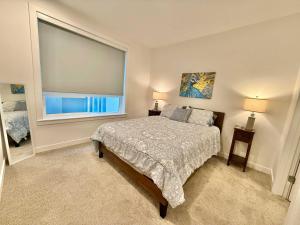 Garden Towers CondominiumModern Condo with Luxury Amenities的一间卧室，里面有一张床和一扇大窗户。