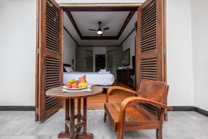 a room with a table with a bowl of fruit on it at wisdom mystery Hotel in Luang Prabang