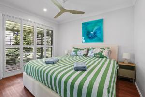 凯阿玛Kiama Beach Retreat - Big Yard & Movie Lounge的一间卧室配有一张带绿色和白色毯子的床