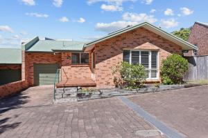 凯阿玛Kiama Beach Retreat - Big Yard & Movie Lounge的前面有车道的砖房