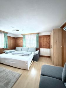 ein Schlafzimmer mit zwei Betten und einer Couch in der Unterkunft Apartment Juen in Tobadill