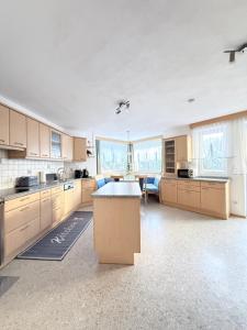 eine große Küche mit Holzschränken und einem Tisch in der Unterkunft Apartment Juen in Tobadill + 10 Fotos