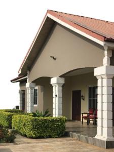 TrofwiにあるMcari suiteの赤い椅子が置かれたポーチのある家