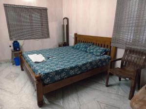 a small bedroom with a bed and a chair at Aala Stays in Tirunelveli