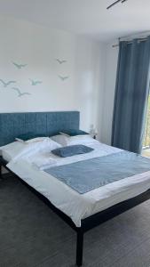 a large bed in a bedroom with a blue curtain at Pensjonat VICTORIA in Ustka