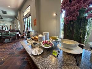 a kitchen with a counter with bowls of food on it at Teak Garden Resort, Chiang Rai in Chiang Rai