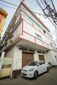 Un coche blanco aparcado delante de un edificio en Hotel Evergreen, en Āsansol