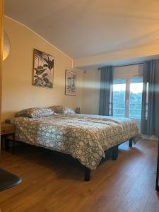ein Schlafzimmer mit einem Bett und einem großen Fenster in der Unterkunft L Appart du Suran 