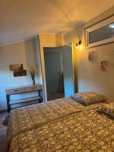 ein Schlafzimmer mit einem Bett und einem Tisch und einem Fenster in der Unterkunft L Appart du Suran 