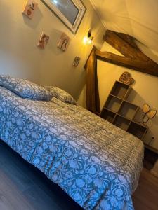 ein Schlafzimmer mit einem Bett mit einer blauen Bettdecke in der Unterkunft L Appart du Suran 