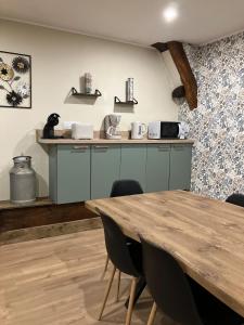 eine Küche mit blauen Schränken und einem Holztisch in der Unterkunft L Appart du Suran  + 7 Fotos