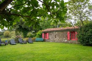 Grand-LandesGite de l'Hubertiere的院子里有一座石头建筑，里面摆放着椅子和长凳。