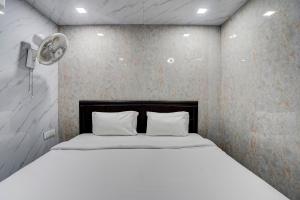 Hotel O POP A Happy Hours Plaza في نيودلهي: سرير مع وسادتين في غرفة