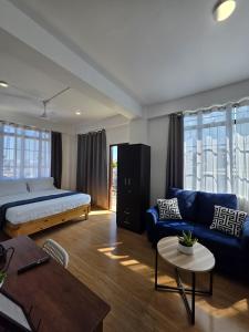 una camera da letto con un letto, un divano e un tavolo di The Olive Inn a Shillong