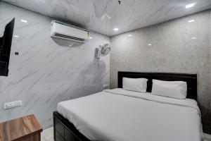 Hotel O POP A Happy Hours Plaza في نيودلهي: غرفة نوم بسرير ومكيف