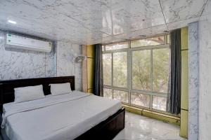 Hotel O POP A Happy Hours Plaza في نيودلهي: غرفة نوم بسرير كبير ونافذة