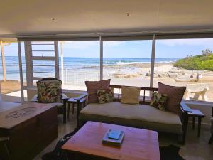 un soggiorno con divano e vista sulla spiaggia di The Kei Mouth Guest Lodge Collection a Kei Mouth