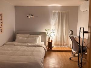 仁川市Hotel Amy的一间卧室，配有一张床、一张桌子和一把椅子 更多51张照片