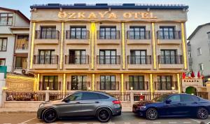 Dos coches aparcados delante de un hotel. en Özkaya hotel, en Sivas