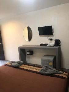 ein Zimmer mit einem Bett und einem Schreibtisch mit einem Fernseher in der Unterkunft Phi Phi Green House & Sunsky Hostel in Ko Phi Phi