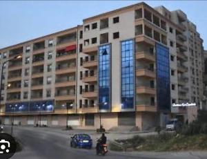 a large building with a man on a motorcycle in front of it at F3 Draria équipé Alger in Draria