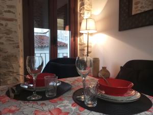 a table with two wine glasses and a bowl on it at Las Golondrinas in Galaroza