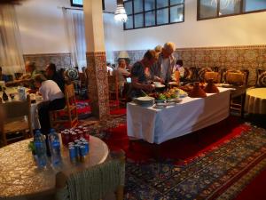 a group of people standing around a table with food on it at Auberge Kasbah Amoun in Taliouine