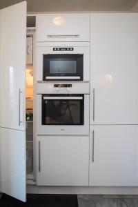 帕西Mont Blanc Views Apartments的白色的厨房配有微波炉和烤箱 更多12张照片