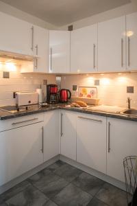 帕西Mont Blanc Views Apartments的配有白色橱柜和台面的厨房