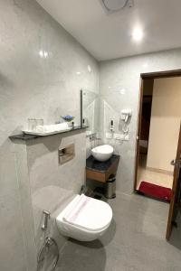 a bathroom with a white toilet and a sink at The Rivanta Hotel Near Airport Road Mohali Zirakpur Chandigarh in Zirakpur