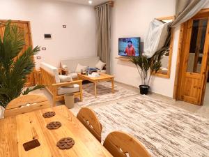 Deluxe SIWA في ‘Izbat Ţanāţī: غرفة معيشة مع طاولة وأريكة