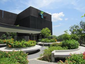 a black building with flowers in front of it at D'Resort @ Downtown East in Singapore