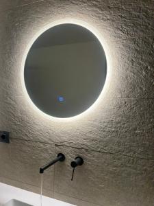 a round mirror on the wall of a bathroom at Casa Camas, wide 2bedroom, feel the mountain in Breuil-Cervinia +38 photos