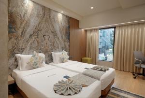 ムンバイにあるPlanet Boutique Hotelの壁画のあるホテルルーム内のベッド2台 +26枚の写真