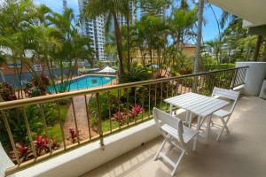 ein Balkon mit Tisch und Stühlen und ein Pool in der Unterkunft Serenity by the Sea in Gold Coast