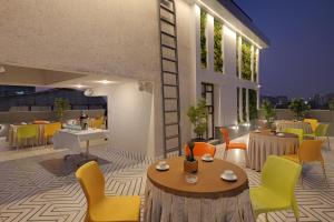 ムンバイにあるPlanet Boutique Hotelの建物内のテーブルと椅子のあるレストラン