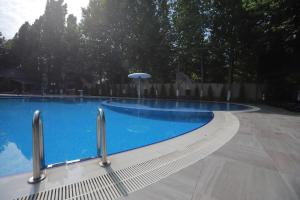 a large blue swimming pool with an umbrella next to it at Vogue Nabran Hotel in Xaçmaz
