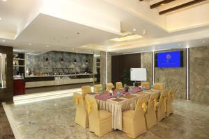 a conference room with a long table and yellow chairs at Planet Boutique Hotel in Mumbai