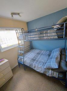 ein Schlafzimmer mit einem Etagenbett mit einer blauen Wand in der Unterkunft Antonia's Place 337 California Sands in Scratby