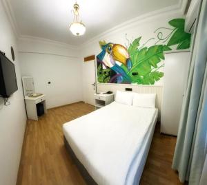 ein Schlafzimmer mit einem weißen Bett und einem Gemälde an der Wand in der Unterkunft Sufi Homes in Konya