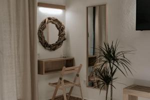 a room with a chair and a mirror and a plant at Villas Gemeli in Ammouliani