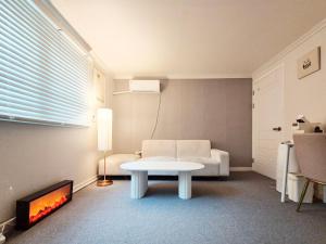 ein Wohnzimmer mit einem weißen Tisch und einem Kamin in der Unterkunft Baeksan Island in Daejeon