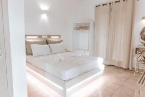 a white bedroom with a white bed in a room at Villas Gemeli in Ammouliani