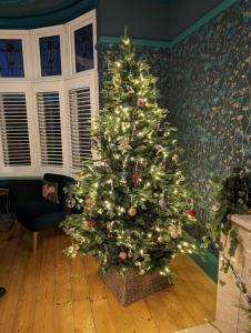 a christmas tree sitting in a living room with at Gorwel is an Art Deco 1930s villa with sea views in Deganwy