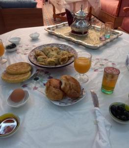a table with two plates of food and orange juice at Diyafat Bladi in Oujda